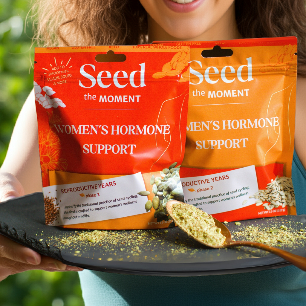 a woman holding a platter with seed the moment hormone support and a spoonful of seeds.